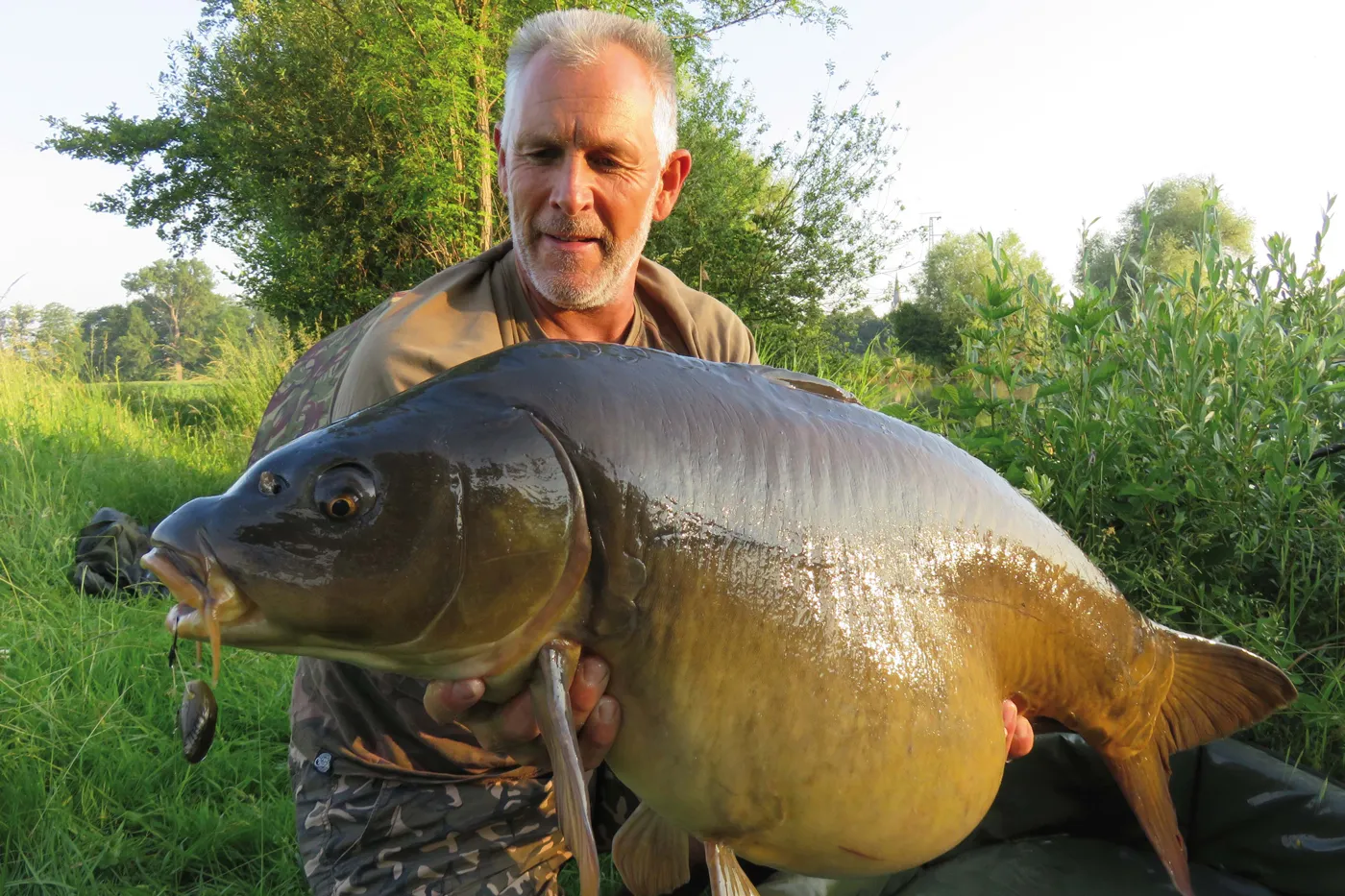 Angler mit Fisch und Carp Shells Köder.